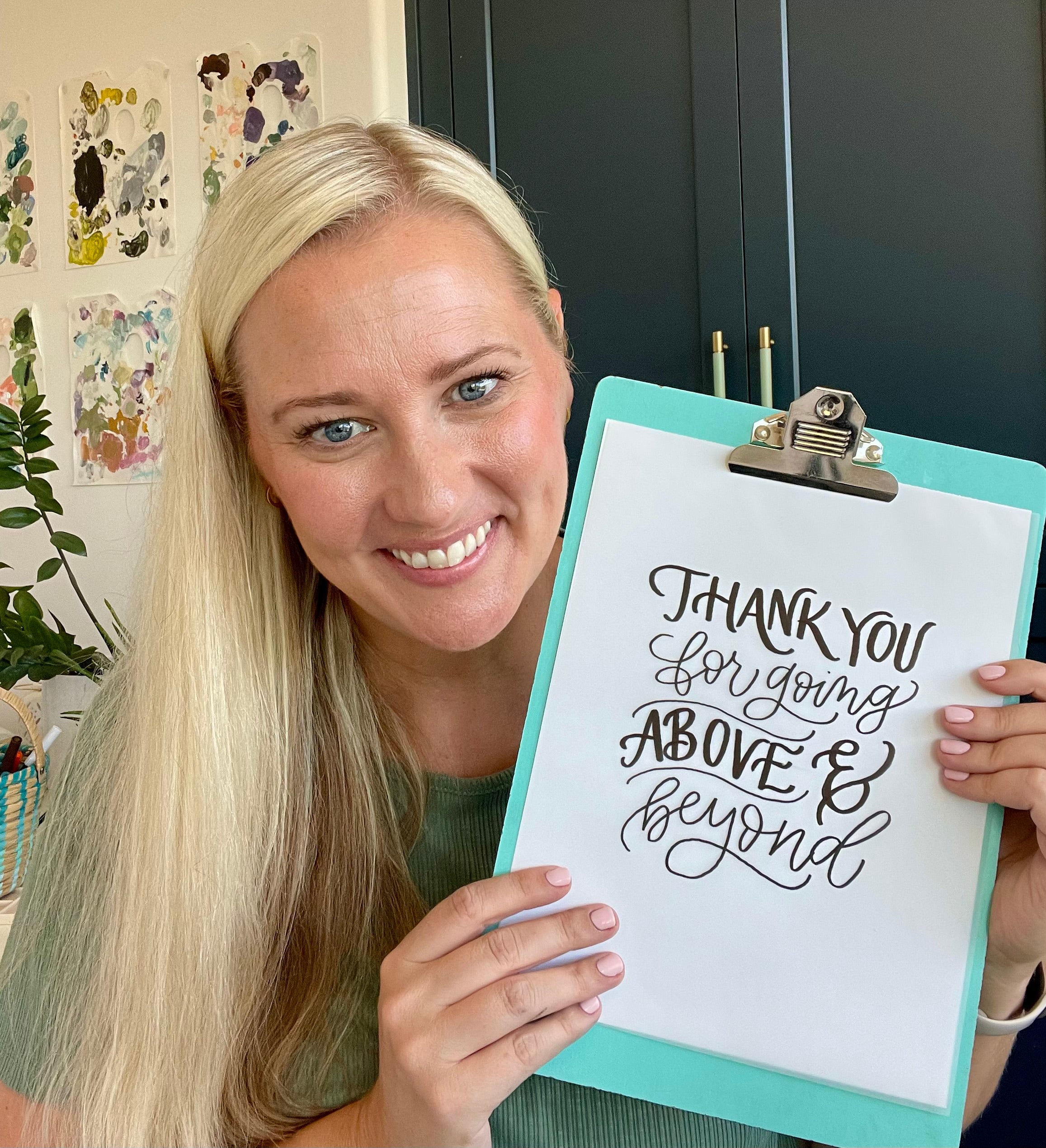 Woman holding a sign with 'Thank you for going above and beyond' text